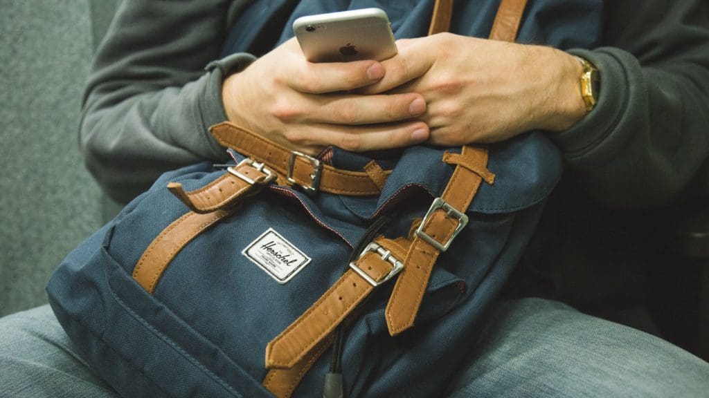 Man holding phone and bag