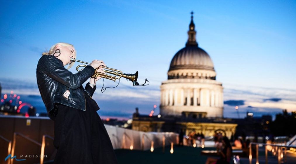 Girl playing trumpet at Madison, London. 