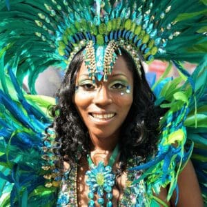 Performer at Notting Hill Carnival dressed in green costume with headdress