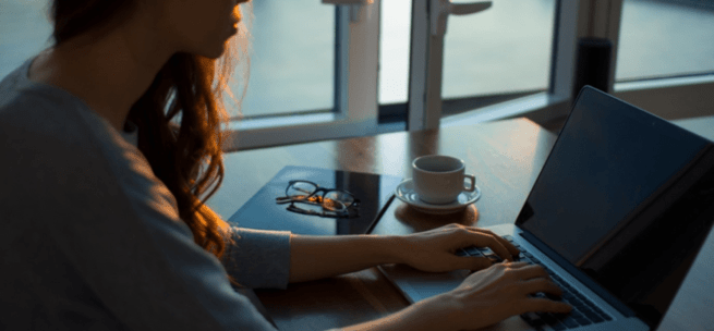 A person sitting at a table working at a computer