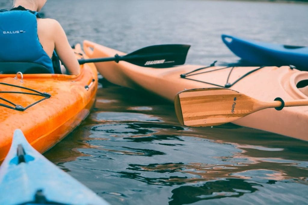 People sitting in kayaks on a body of water