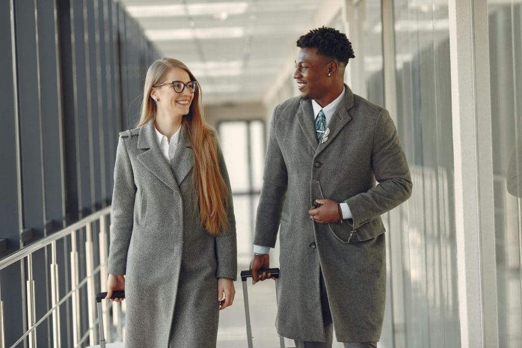 A man and a woman smiling while travelling through an airport